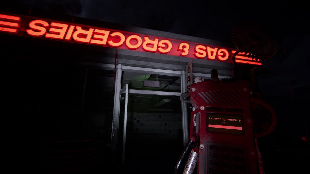 Un dispositivo de Shift 87 muestra el mensaje de reporte de una anomalía bajo un letrero rojo de gasolinera